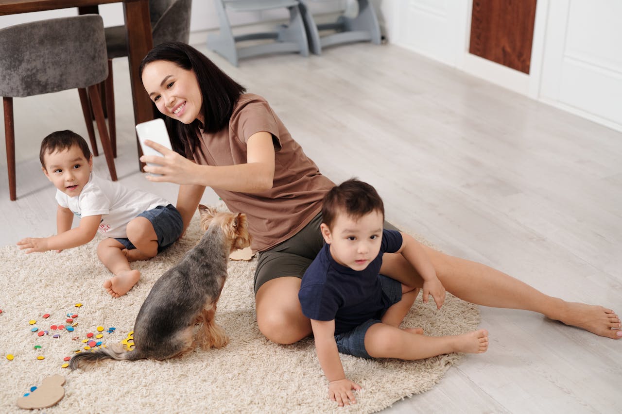 gallery-3 A mother capturing a selfie with her two children and dog, enjoying quality time indoors.